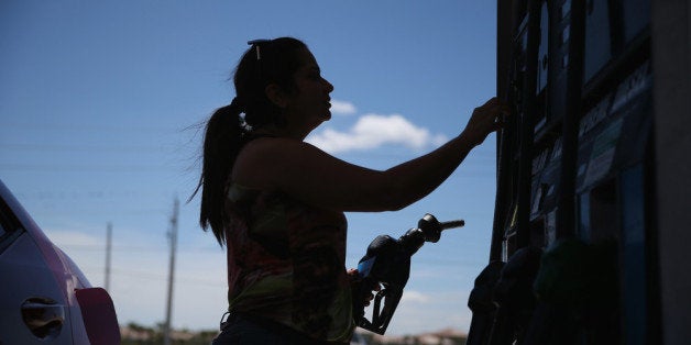 PEMBROKE PINES, FL - APRIL 21: Dora Galeano pumps gas at the Victory gas station on April 21, 2014 in Pembroke Pines, Florid
