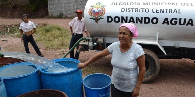 A tanker fills containers with water in a poor neighbourhood on the outskirts of Tegucigalpa on August 7, 2014. Honduras and