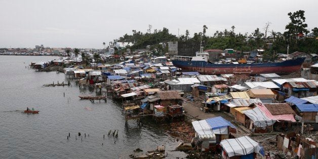 Makeshift shelters where typhoon survivors live are built around a cargo ship which was washed ashore nearly three months aft