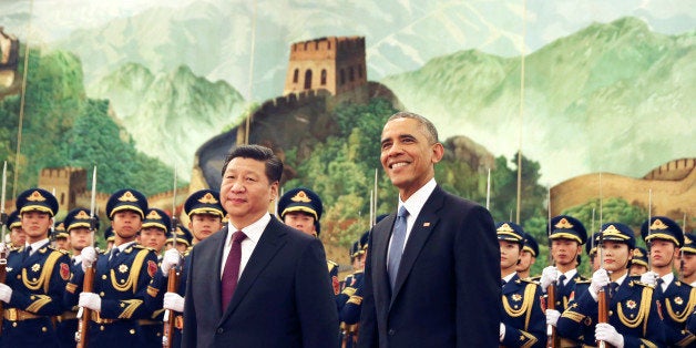 U.S. President Barack Obama, right, smiles after a group of children waved flags and flowers to cheer him during a welcome ceremony with Chinese President Xi Jinping at the Great Hall of the People in Beijing, China Wednesday, Nov. 12, 2014. When Xi Jinping took the reins of a booming China two years ago, President Barack Obama saw an opportunity to remake America's relationship with the Asian power. But even after Obama's unusually robust efforts to forge personal ties with Xi, the two leaders are meeting in Beijing amid significant tensions, both old and new. (AP Photo/Andy Wong)