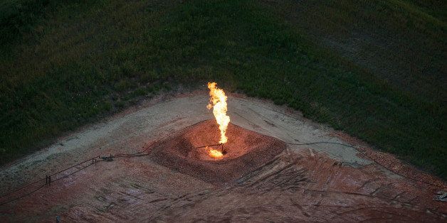 WATFORD CITY, ND - JULY 30: A gas flare is seen in an aerial view in the early morning hours of July 30, 2013 near Watford City, North Dakota. Gas flares are caused when pressure release valves release excess natural gas from an oil pumpjack; the gas is then ignited to burn off the fumes. North Dakota has seen a boom in oil production thanks to new drilling techniques including horizontal drilling and hydraulic fracturing. (Photo by Andrew Burton/Getty Images)