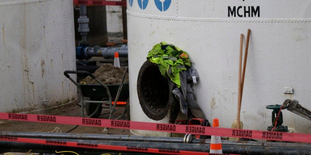 CORRECTS STATE TO W.VA. INSTEAD OF VA. - Work continues around a storage tank with the chemical designation MCHM, 4-methylcy