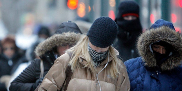 FILE- In this Jan. 28, 2014, file photo, morning commuters bundle up in Chicago. Meteorologists are confidently forecasting frigid polar air will plunge south into the northern plains, Midwest and then the East Coast from next Tuesday, Jan. 6, 2015, through Thursday. National Weather Service meteorologist Paul Kocin, an expert on winter storms, said it will rival last year's January Arctic outbreak that introduced the phrase "polar vortex" to America. (AP Photo/Kiichiro Sato, File)