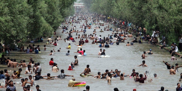 People cool themselves off in a canal in Lahore, Pakistan, where temperature reached 46 degrees Celsius (104 Fahrenheit) on Sunday, June 8, 2014. Many cities in Pakistan are facing heat wave conditions with temperatures reaching 50 degrees Celsius (122 Fahrenheit) in some places. (AP Photo/K.M. Chaudary)