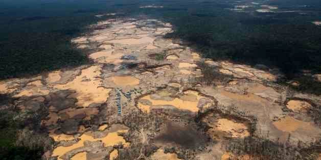 This Nov. 11, 2014 aerial photo, shows a deforested area dotted with blue tarps, marking the area where miners reside, and cr