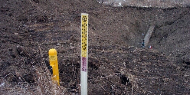 A warning sign shows the location of a 12-inch oil pipeline owned by Bridger Pipeline Co. that spilled up to 50,000 gallons o