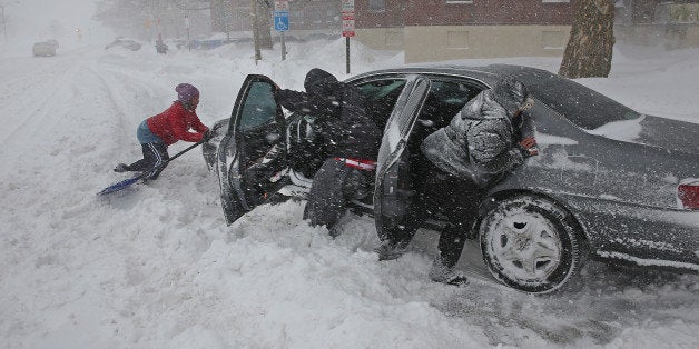 BOSTON - FEBRUARY 2: Left to right, Shirley Jean helps with Mike Jackson's car along with his wife Cay Jackson all try to move the car free on Old Colony Boulevard Boston. (Photo by David L. Ryan/The Boston Globe via Getty Images)