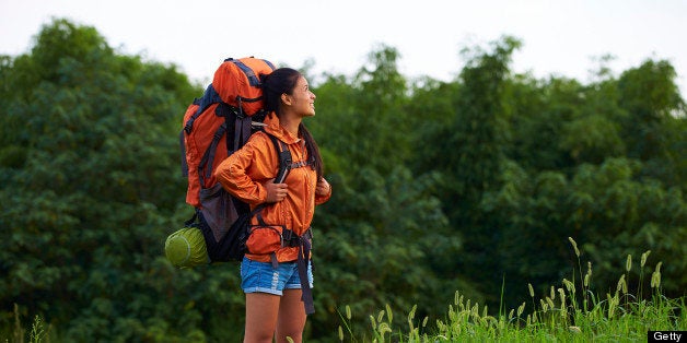 young woman carrying big backpack and enjoy the beauty of the nature