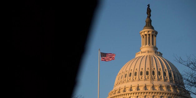 A U.S. flag flies on top of the Capitol building at sunset in Washington, D.C., U.S., on Thursday, Dec. 12, 2013. A U.S. budget accord is on track to win passage in Congress largely because its most important accomplishment is pushing off automatic spending cuts that neither party likes. Photographer: Andrew Harrer/Bloomberg via Getty Images