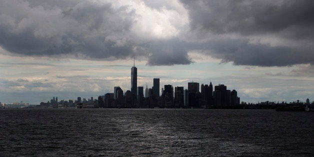 Rain clouds gather over the lower Manhattan skyline, Saturday, Aug. 23, 2014, in New York. (AP Photo/John Minchillo)