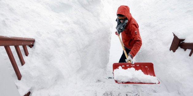 Kim Taylor, of Norwood, Mass., right, shovels a path in the snow in front of her home Sunday, Feb. 15, 2015, in Norwood. A storm brought a new round of wind-whipped snow to New England on Sunday, threatening white-out conditions in coastal areas and forcing people to contend with a fourth winter onslaught in less than a month. (AP Photo/Steven Senne)