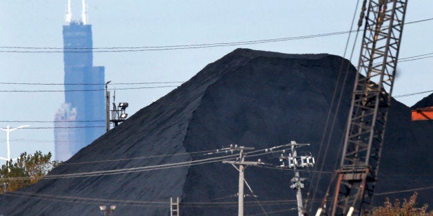 FILE - In this Oct. 25, 2013 file photo, the Willis Tower in downtown Chicago provides a backdrop to a huge mound of petroleum coke in a residential area in southeast part of the city. Gov. Pat Quinn announced Monday, Jan. 13, 2014, that emergency rules for the storage and handling of petroleum coke are being filed this week with the Illinois Secretary of State. "Petcoke" is a byproduct of oil refining that's been accumulating along shipping channels and has sparked health and environmental concerns. (AP Photo/Charles Rex Arbogast, File)