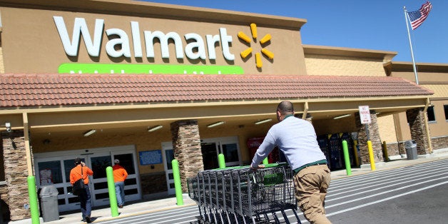 MIAMI, FL - FEBRUARY 19: Walmart employee Yurdin Velazquez pushes grocery carts at a Walmart store on February 19, 2015 in M