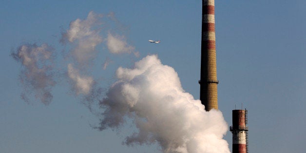 FILE - In this Nov. 13, 2014 file photo, a passenger airliner flies past steams emitted from a coal-fired power plant in Beijing, China. Six countries produce nearly 60 percent of global carbon dioxide emissions. China and the United States combine for more than two-fifths. The planetâs future will be shaped by what these top carbon polluters do about the heat-trapping gases blamed for global warming. (AP Photo/Andy Wong, File)