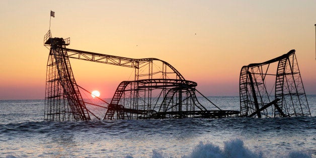 FOR USE AS DESIRED, YEAR END PHOTOS - FILE - The sun rises in Seaside Heights, N.J., Monday, Feb. 25, 2013, behind the Jet Star Roller Coaster which has been sitting in the ocean after part of the Funtown Pier was destroyed during Superstorm Sandy. The private owners of the amusement pier that collapsed in Seaside Heights were working with insurers to devise a plan to dismantle the ride and get it out of the ocean. (AP Photo/Mel Evans, File)