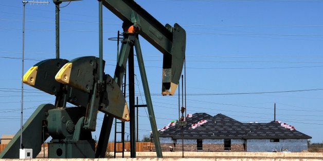 In this Monday, Sept. 23, 2013 photo, a pump jack works beside the site of new home construction, in Midland, Texas. The West Texas town is in the middle of an oil boom with thousands of workers in need of housing. (AP Photo/Pat Sullivan)