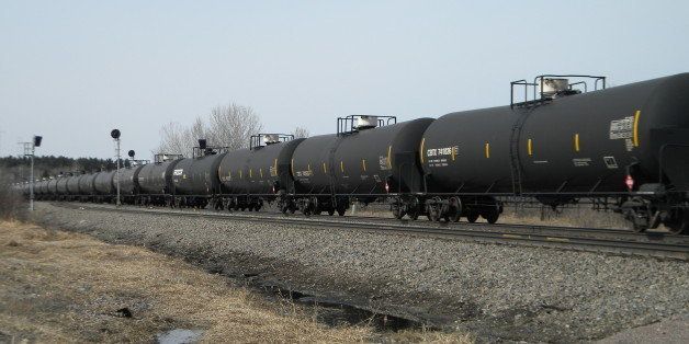 In this April 15, 2014 photo, an oil-tank train operated by Burlington Northern Santa Fe Corp., based in Fort Worth, Texas, cruises east alongside U.S. 10, a few miles outside of Staples, Minn. Multiple BNSF oil-tank trains travel through Staples every day, pulling about 110 tanks, sometimes more, of highly volatile crude from the Bakken shale fields in North Dakota to refineries east and south of Minnesota. (AP Photo/Mike Cronin)