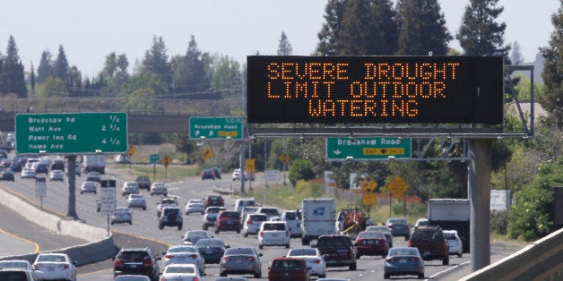 Motorists pass a sign, Thursday, April 2, 2015, in Rancho Cordova, Calif., reminding them to reduce water...