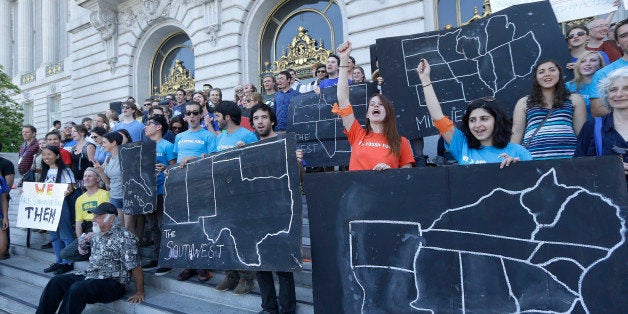 College students and supporters hold up signs at a rally to support fossil fuel divestment outside of City Hall in San Francisco, Thursday, May 2, 2013. In an effort to slow the pace of climate change, students at more than 200 colleges are asking their schools to stop investing in fossil fuel companies. (AP Photo/Jeff Chiu)