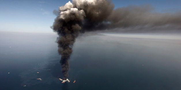 FILE - In this Wednesday, April 21, 2010 file photo, oil can be seen in the Gulf of Mexico, more than 50 miles southeast of Venice on Louisiana's tip, as a large plume of smoke rises from fires on BP's Deepwater Horizon offshore oil rig. Legal battles arising from the 2010 Gulf of Mexico oil spill play out in two federal courts this coming week. On Monday, Feb. 2, 2015, trial resumes in a federal district courtroom where BP and a minority partner in its ill-fated Macondo well are trying to fend off billions in Clean Water Act penalties. On Tuesday, federal appeals court judges hear an appeal in which BP seeks the ouster of the man overseeing payments to businesses claiming harm from the spill. (AP Photo/Gerald Herbert, File)