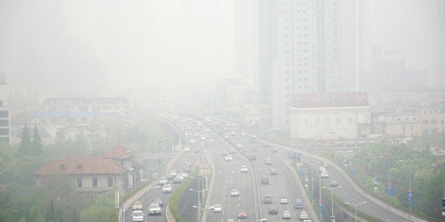 Cars are seen on an elevated road on a heavy polluted day in Shanghai on April 19, 2015. AFP PHOTO / JOHANNES EISELE