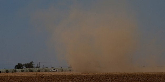 MADERA, CA - APRIL 24: A dust devil kicks up dirt as it forms over an empty field on April 24, 2015 in Madera, California. A