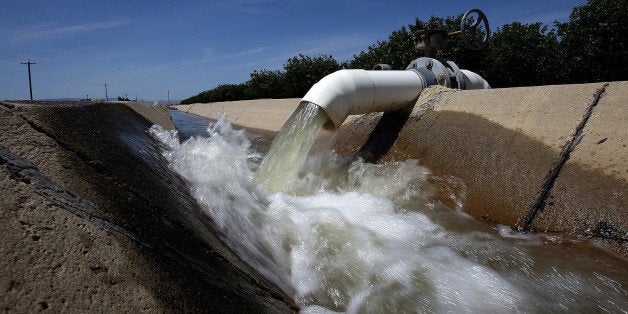 FIREBAUGH, CA - APRIL 24: Water is pumped into an irrigation canal at an almond orchard on April 24, 2015 in Firebaugh, Cali