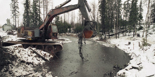 Heavy machinery is used to scoop up oily debris from the water s of a tributary of the Kolva River, some 27 miles north of the Russian City of Usinsk, Friday, Oct. 28, 1994. Alaska Gov. Walter J. Hickel and Alaskan experts on cleaning up oil spills plan to fly to Russian next week to offer their help in contending with the huge oil spill near the Arctic Circle, according to sources with the regional Environment Ministry. (AP Photo/Alexander Zemlianichenko)