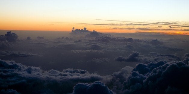 Sunset over the clouds pictured from a plane between Martinique and the Guadeloupe French Islands on May 9, 2015. AFP PHOTO/