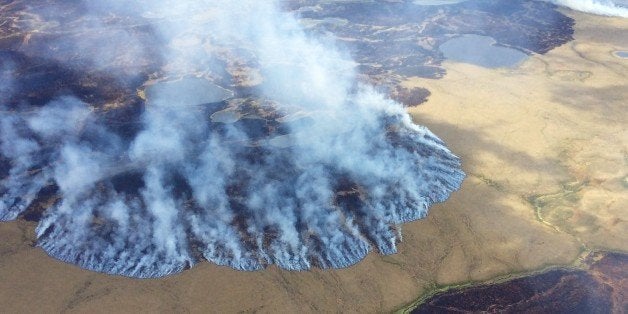 In this Sunday, June 7, 2015 photo, smoke rises from the Bogus Creek Fire, one of two fires burning in the Yukon Delta National Wildlife Refuge in southwest Alaska. Fire managers said Monday that weekend rain helped tamp down the fires which, together, total about 63 square miles. (Matt Snyder/Alaska Division of Forestry via AP)