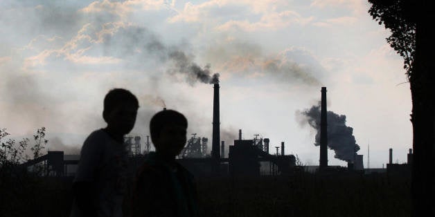 Sofia, BULGARIA: TO GO WITH AFP STORY 'Bulgaria's biggest industrial polluters struggle to meet EU eco norms' Children walk by the smoking chimneys of the largest metal working company in Bulgaria, a former symbol of communist-era 'Kremikovtzi,' in the capital Sofia, 30 September 2006. Metallurgy and chemical plants, the biggest environmental polluters in Bulgaria, are in a race against time to meet EU ecological norms ahead of joining the European Union on 01 January 2007. AFP PHOTO / VALENTINA PETROVA (Photo credit should read VALENTINA PETROVA/AFP/Getty Images)