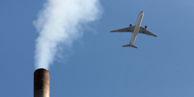 An aircraft flies past a smoke-stack in Beijing on May 30, 2012. According to government sources, China is to set aside around two billion yuan (320 million USD) as part of drive to cut carbon emissions and produce energy-saving vehicles. AFP PHOTO / Ed Jones (Photo credit should read Ed Jones/AFP/GettyImages)