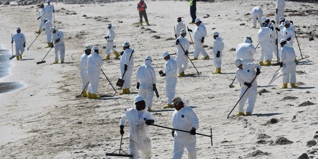 Workers clean oil from the rocks and beach near Refugio State Beach in Goleta, California, May 22, 2015. The oil company behind a crude spill on the California coast vowed to do the 'right thing' to clear up the mess, even as reports emerged of past leaks involving its pipelines. Plains All American Pipeline made the pledge as it said nearly 8,000 gallons of oil had been scooped up, out of some 21,000 gallons believed to have flooded into the ocean near Santa Barbara, northwest of Los Angeles. AFP PHOTO/ MARK RALSTON (Photo credit should read MARK RALSTON/AFP/Getty Images)