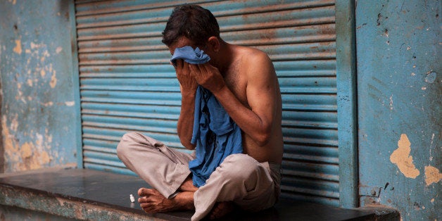 An Indian man wipes sweat off his face on a hot summer day in New Delhi, India, Sunday, May 24, 2015. Heat wave has tightened