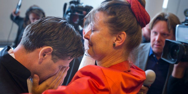 Urgenda Foundation director Marjan Minnesma hugs lawyer Roger Cox, left, after a Dutch court ordered the government to cut the country's greenhouse gas emissions by at least 25 percent by 2020 in a groundbreaking climate case that activists hope will set a worldwide precedent in The Hague, Netherlands, Wednesday, June 24, 2015. The Hague District Court made the ruling Wednesday in a case brought by a sustainability organization on behalf of some 900 citizens, claiming that the the government has a duty of care to protect its citizens against looming dangers. (AP Photo/Peter Dejong)