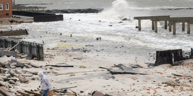 ATLANTIC CITY, NJ - OCTOBER 30: A man walks over debsris where a 2000-foot section of the 'uptown' boardwalk was destroyed by flooding from Hurricane Sandy on October 30, 2012 in Atlantic City, New Jersey. The storm has claimed at least 33 lives in the United States, and has caused massive flooding across much of the Atlantic seaboard. US President Barack Obama has declared the situation a 'major disaster' for large areas of the US East Coast including New York City. (Photo by Mario Tama/Getty Images)