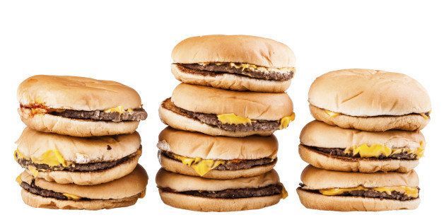 a very tall pile of cheesburgers isolated over a white background