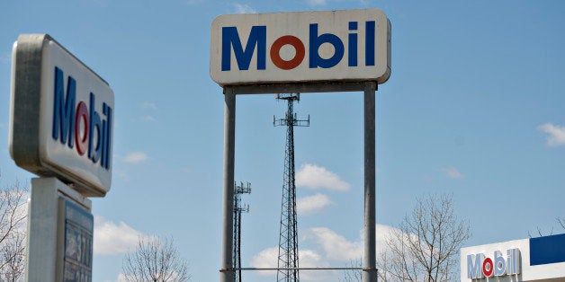 Mobil signage stands at the Kickapoo Service Center in Edwards, Illinois, U.S., on Thursday, April 25, 2013. Exxon Mobil Corp., the world's largest company by market value, said net income rose as widening chemical margins made up for lower crude production and prices. Photographer: Daniel Acker/Bloomberg via Getty Images