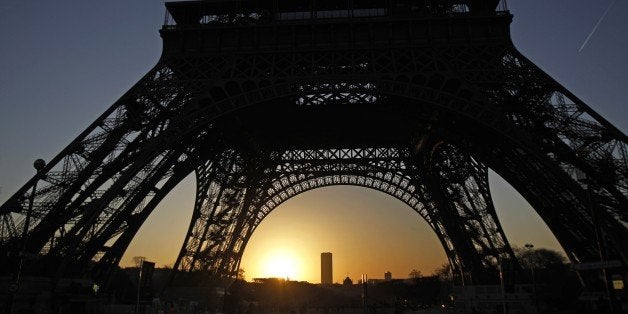 The sun rises behind the Eiffel Tower in Paris, Saturday, Jan. 14, 2012. (AP Photo/Michel Euler)