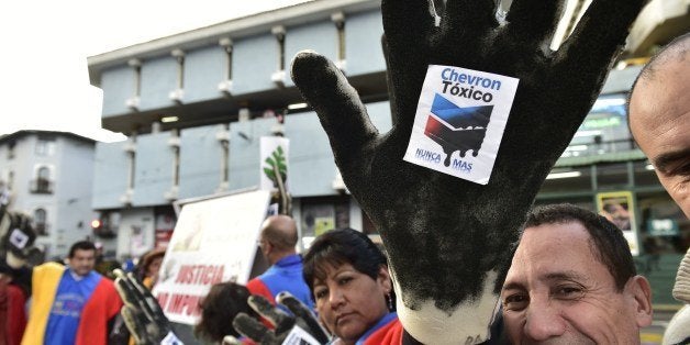 Activists protest against US multinational energy corporation Chevron at a square in Quito on May 21, 2014. Ecuadorean ecology groups added Wednesday to a series of demonstrations in different parts of the world against Chevron, during the 'International anti-Chevron Day'. AFP PHOTO / RODRIGO BUENDIA (Photo credit should read RODRIGO BUENDIA/AFP/Getty Images)