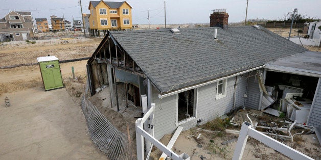 A home sits in ruins near others still being rebuilt on the second anniversary of Superstorm Sandy Wednesday, Oct. 29, 2014, in the Ortley Beach sectionToms River, N.J. Officials and residents in towns throughout coastal areas of New York and New Jersey are taking stock of the recovery from Superstorm Sandy on the second anniversary of the storm. The October 2012 storm devastated the oceanfront coastline and caused catastrophic flooding in New York and cities in New Jersey. (AP Photo/Mel Evans)