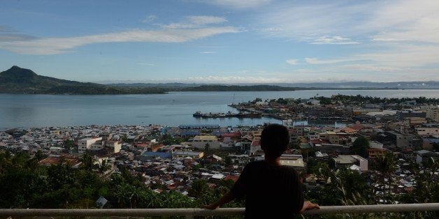 To go with PHILIPPINES-TYPHOON-CLIMATE, Focus by Ted AljibeThis photo taken on November 2, 2015, shows a young boy looking from a mountain overlooking downtown Tacloban City, Leyte province, central Philippines, ahead of the two-year anniversary of the devastating typhoon Haiyan. Two years after a super typhoon devastated the Philippines and sounded a global alarm on climate change, a massive rebuilding programme has had big successes but at least one million survivors are still without safe homes. AFP PHOTO / TED ALJIBE (Photo credit should read TED ALJIBE/AFP/Getty Images)