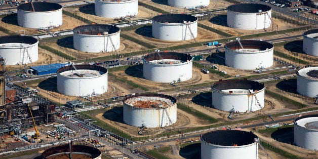 Oil storage tanks sit at the Esso oil refinery, operated by Exxon Mobil Corp. in Fawley, U.K., on Friday, Oct. 2, 2015. A 50 percent drop in crude prices in the past year has hit earnings for oil and gas producers, forcing them to slash capital spending and scale back unprofitable operations. Photographer: Simon Dawson/Bloomberg via Getty Images