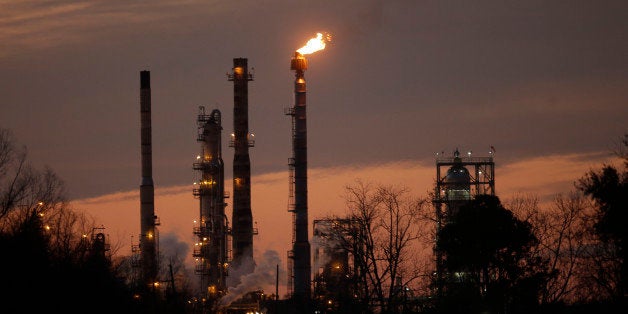 Stacks and burn-off from the Exxon Mobil refinery are seen at dusk in St. Bernard Parish, La., Friday, Feb. 13, 2015. (AP Photo/Gerald Herbert)