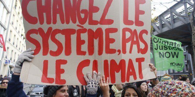 Demonstrators hold up a banner reading 'Change the system, not the climate' as protesters take part in a march against unemployment and austerity on December 5, 2015 in Paris. / AFP / MATTHIEU ALEXANDRE (Photo credit should read MATTHIEU ALEXANDRE/AFP/Getty Images)