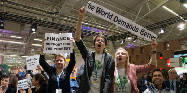 NGO representatives and participants stage a sit-in protest closed to the plenary session to denounce the first draft COP21 C