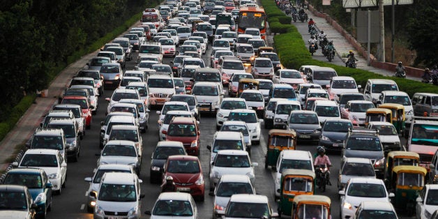 FILE - In this Tuesday, Sept. 23, 2014 file photo, traffic moves at dusk in New Delhi, India. The city is imposing new rules