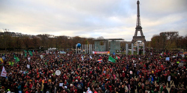 Activists gather near the Eiffel Tower, in Paris, Saturday, Dec.12, 2015 during the COP21, the United Nations Climate Change Conference. As organizers of the Paris climate talks presented what they hope is a final draft of the accord, protesters from environmental and human rights groups gather to call attention to populations threatened by rising seas and increasing droughts and floods. (AP Photo/Thibault Camus)