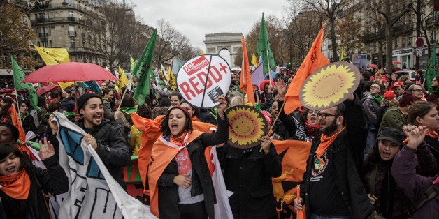 PARIS, FRANCE - DECEMBER 12: Activist shout during a demonstration near the Arc de Triomphe at the Avenue de la Grande Armee boulevard on December 12, 2015 in Paris, France. The final draft of a 195-nation landmark agreement on climate has been submitted at the United Nations conference on climate change COP21, aimed at limiting greenhouse gas emissions and keeping planetary warming below 2.0 degrees Celsius. (Photo by Agung Parameswara/Getty Images)