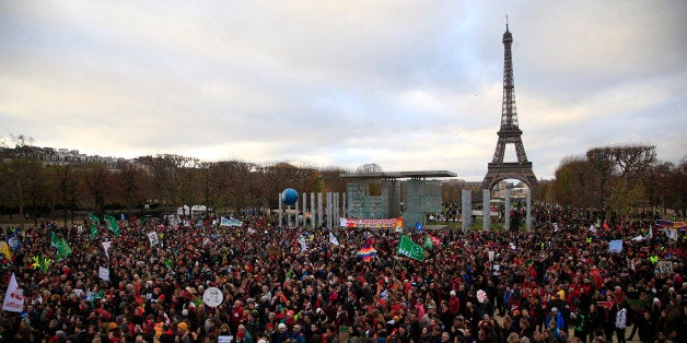 Activists gather near the Eiffel Tower, in Paris, Saturday, Dec.12, 2015 during the COP21, the United Nations Climate Change Conference. As organizers of the Paris climate talks presented what they hope is a final draft of the accord, protesters from environmental and human rights groups gather to call attention to populations threatened by rising seas and increasing droughts and floods. (AP Photo/Thibault Camus)